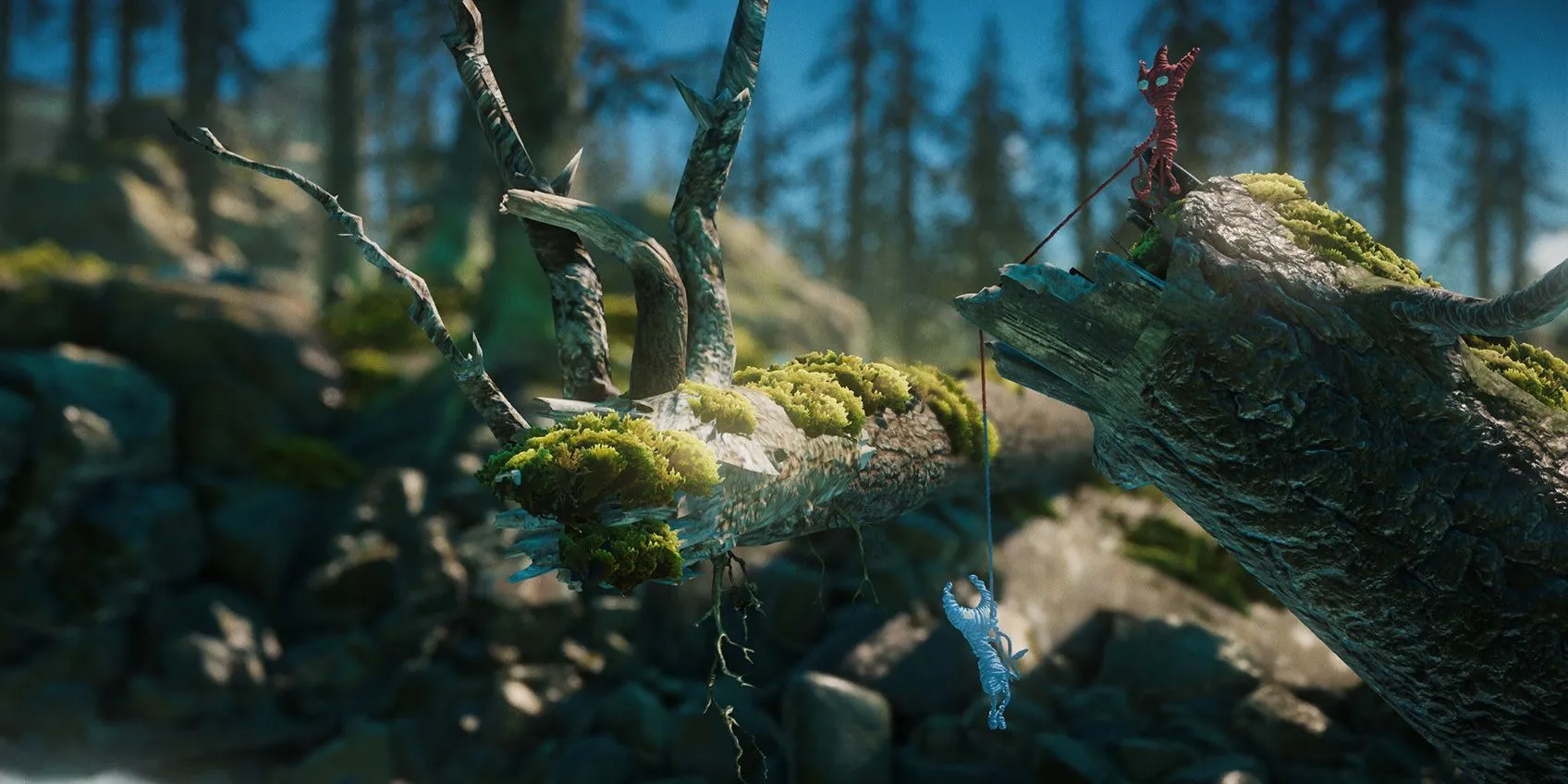 Hai nhân vật Yarny màu đỏ và xanh giúp đỡ lẫn nhau trong game Unravel Two
