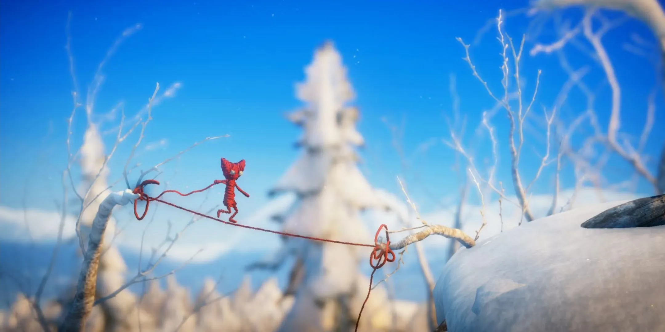 Nhân vật Yarny làm từ sợi len đang đi trên một sợi dây trong game Unravel